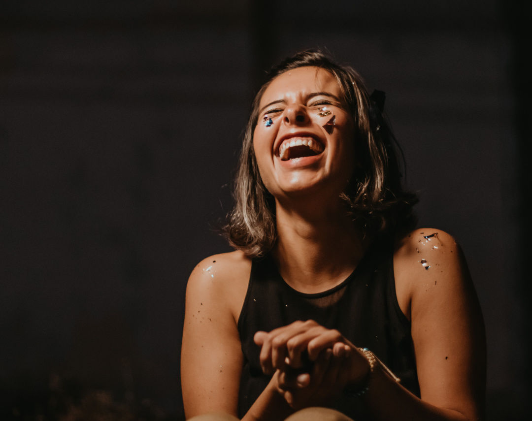 Girl joyfully throwing her head back in laughter
